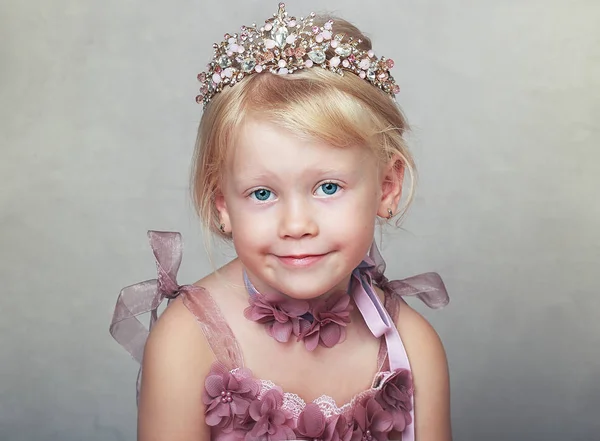 美丽的女孩粉红色的礼服小公主在她的手中挖皇冠 — 图库照片
