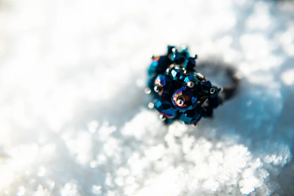 beautiful ring with blue gems in the snow close up