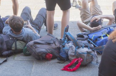 Kaldırımda bir yürüyüş ve dinlenme sırasında yalan çeşitli sırt çantaları