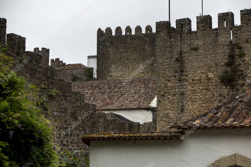 Village, medieval town, Obidos in Portugal. View of white houses, red tiles. A popular tourist destination.
