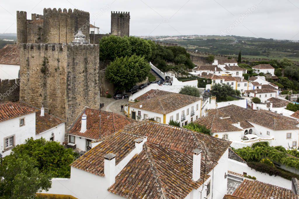 Village, medieval town, Obidos in Portugal. View of white houses, red tiles. A popular tourist destination.