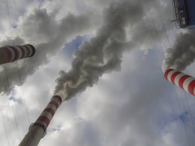 Gökyüzü kaplı yürütmektedir ve yüksek bacalar (duman) (dışarı bırakarak duman)