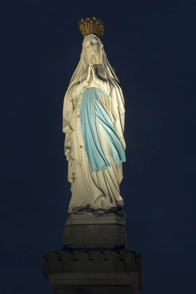 Estatua de Nuestra Señora de la Inmaculada Concepción después de anochecer contra un — Foto de Stock