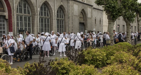 Lourdes, Francie 24. červen 2019: dobrovolníci pomáhající nemocným dostat — Stock fotografie