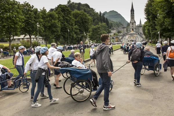 Lourdes, Frankrike 24 juni 2019: volontärer hjälpa de sjuka få t — Stockfoto
