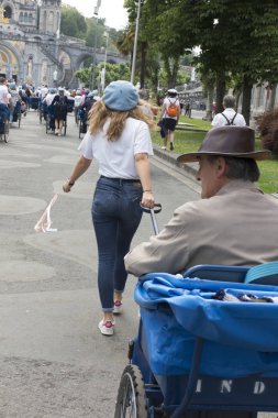 Lourdes, Fransa 24 Haziran 2019: Hastaların Lourdes 'teki Meryem Ana' ya sığınmalarına yardım eden gönüllüler..