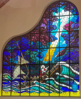 Niechorze, Polonya, 10 Mayıs 2025: Polonya 'da Baltık Denizi üzerinde Niechorze' da bulunan Merhametli Meryem Kilisesi 'nde (orijinal adıyla St. Stanislaus) bir göldeki fırtınanın dinginliğini gösteren lekeli cam pencere.