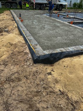 Yassı beton dökmeye ve yüzeyine beton dökülmesine hazır tek bir aile evinin temelleri..