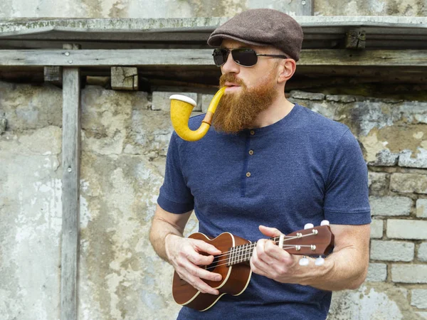 Foto Skäggig Man Trettioårsåldern Rökning Stor Pipa Och Spela Ukulele — Stockfoto