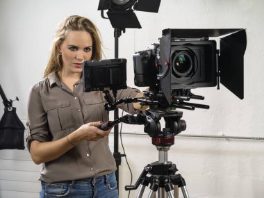 Bir dslr kamera teçhizat bir video çekimi için çalışan bir kadın fotoğrafı.