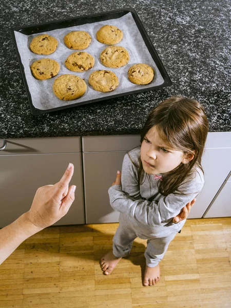 一个小女孩生气的照片 因为她妈妈告诉她 她不能吃烤盘里的巧克力饼干 — 图库照片