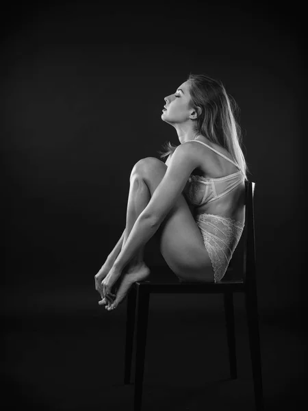 彼女のランジェリーでポーズ 椅子に座ってセクシーな若い女性の写真 — ストック写真