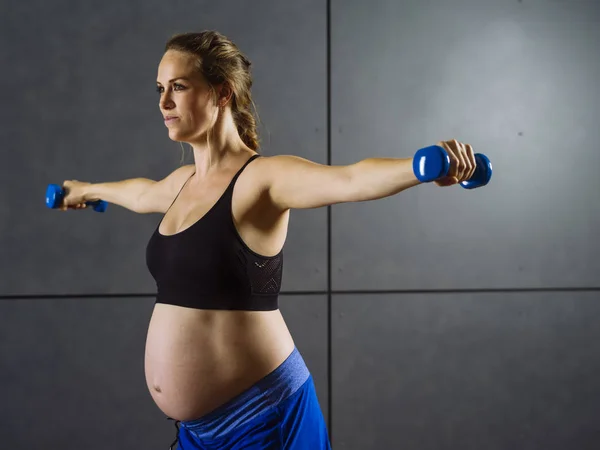 Mulher grávida se exercitando com halteres — Fotografia de Stock
