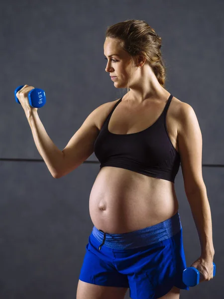 Mujer embarazada haciendo rizos de bíceps — Foto de Stock