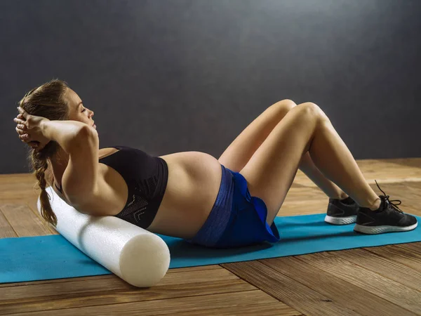 Pregnant woman doing situps — Stock Photo, Image