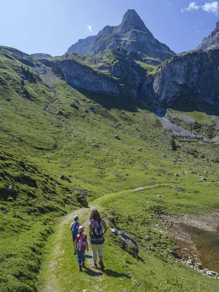 Fiatal család túrázás körül Bannalp Svájcban — Stock Fotó