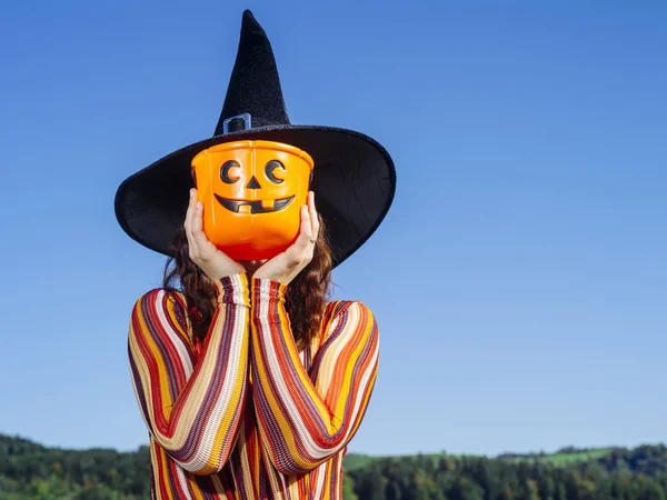 Jovem mulher segurando balde de abóbora para Halloween — Fotografia de Stock