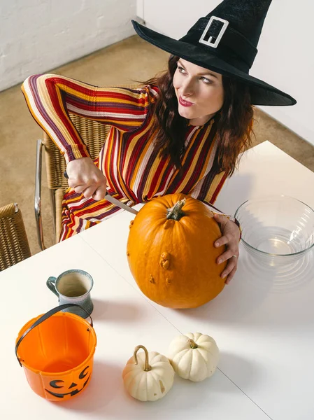 Redhead woman cutting a pumpkin for Halloween — Stock Photo, Image