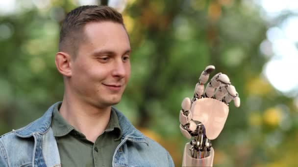 Jonge Man kijkt op zijn Robotic Hand in het Park. Prachtige realistische 3D-animatie. 4k — Stockvideo