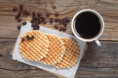 Fincan sıcak kahve ve ev yapımı lezzetli waffle eski ahşap tablo, üstten görünüm 