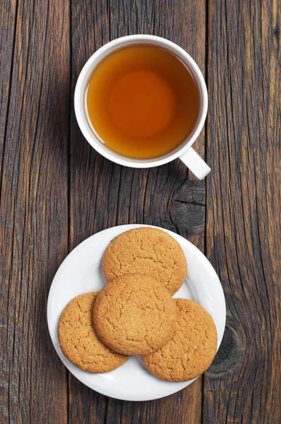 杯茶和燕麦饼干在盘子上老木桌 顶部视图 — 图库照片