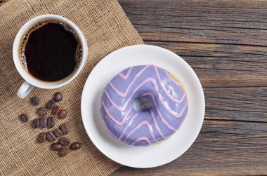 Çörek menekşe sır ve kahve masada eski ahşap, üstten görünüm