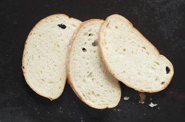 Dilim beyaz ekmek eski siyah metal arka planda üstten görünüm