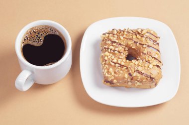 Karamel bir sır ile kare çörek kavrulmuş fındık ve plaka ve hafif kahverengi zemin üzerine kahve çikolata çizgiler ile dekore edilmiştir