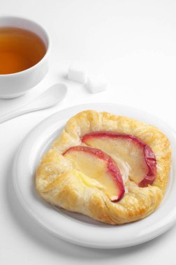 Elmalı tabak ve bardak çay beyaz arka plan üzerinde topuz yakın çekim