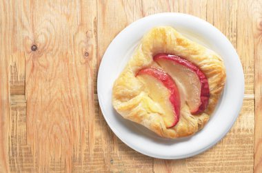 Eski ahşap arka plan üzerinde beyaz tabak, en iyi görünüm için metin alanı ile elmalı çörek