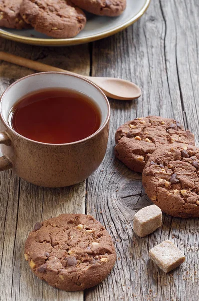 Çikolata kurabiye ile fındık ve çay eski ahşap tablo
