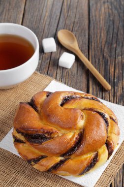 Çikolata kremalı çörek ve çay eski ahşap masa üzerinde Kapat