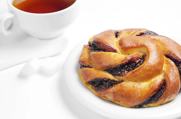 Çikolata kremalı çörek ve çay beyaz arka plan üzerinde kahvaltıda kapat