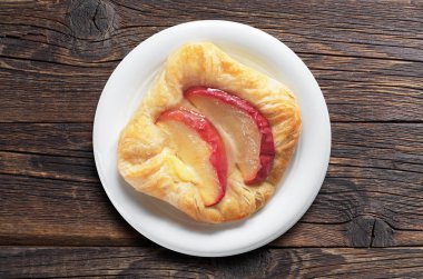 Eski ahşap arka plan, üstten görünüm üzerinde beyaz plaka elmalı çörek