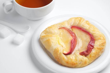 Elma ve çay beyaz arka plan üzerinde topuz yakın çekim