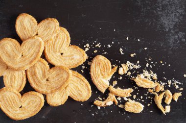 Puf böreği çerezleri tüm ve kırık eski siyah metal arka planda üstten görünüm