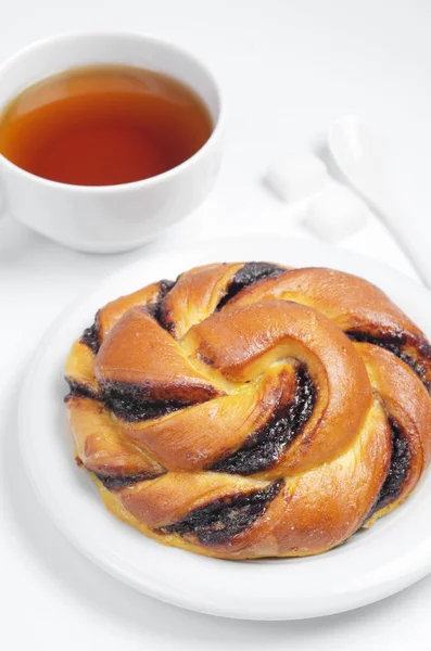 Çikolata kremalı çörek ve çay beyaz arka plan üzerinde kahvaltıda kapat