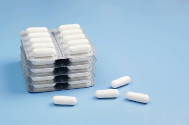 Kabarcıklar mavi masada paketlenmiş ilaç kapsül
