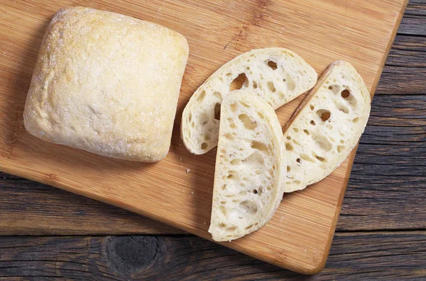 Broden Plakje Italiaans Brood Ciabatta Snijplank Tegen Een Houten Achtergrond — Stockfoto