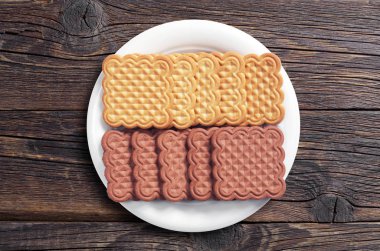 Vanilya ve çikolata kare kurabiye plaka üzerinde eski ahşap arka plan, üstten görünüm