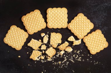 Vanilya kare çerezleri tüm ve kırık eski siyah metal arka planda üstten görünüm