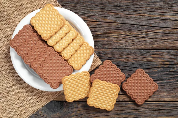 Vanilya ve çikolata kare kurabiye plaka üzerinde eski ahşap masa, üstten görünüm