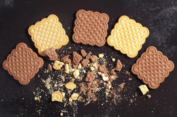 Çikolata ve vanilya kare çerezleri tüm ve kırık eski siyah metal arka planda üstten görünüm