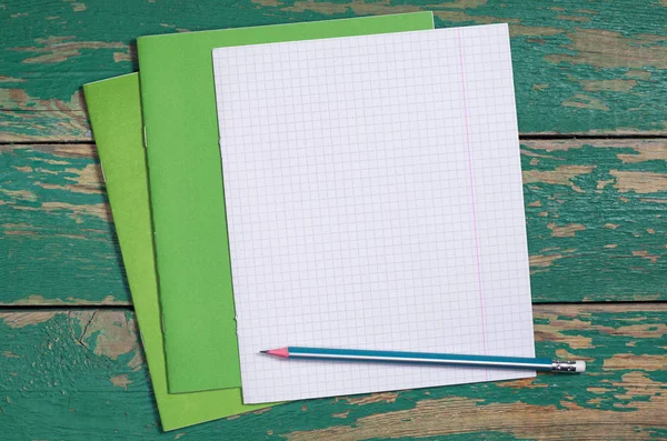 旧绿色木桌上有铅笔的学校笔记本 顶部视图 — 图库照片