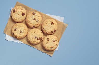Çikolatalı kurabiye kağıt ve mavi tablo, kopya alanı ile üstten görünüm