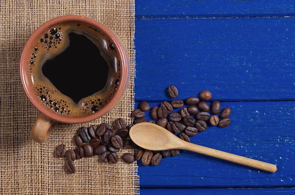 Vista Superior Uma Xícara Café Grãos Guardanapo Mesa Madeira Azul — Fotografia de Stock