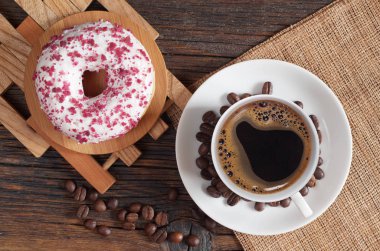 Kırmızı kırıntıları ve eski ahşap bir masa üstten görünüm üzerinde siyah kahve beyaz çörek serpilir