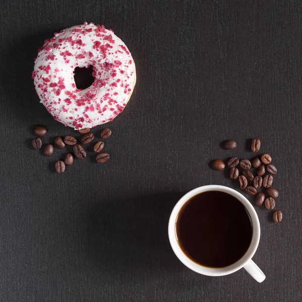 一杯咖啡和一个甜甜的甜甜圈 配以红果的面包屑点缀在黑色的石头背景上 顶部视图 — 图库照片