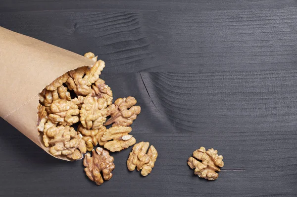 Nueces Dispersas Una Bolsa Papel Sobre Fondo Madera Negro Vista — Foto de Stock