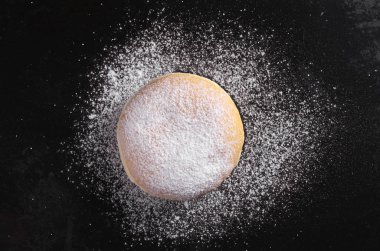 Tatlı çörek berliner ve eski siyah üzerine pudra şekeri metal arka plan, üstten görünüm